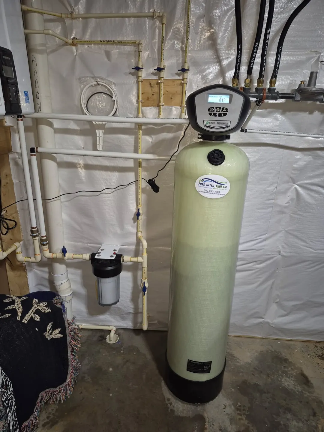 Air-injection filter with an A.O. Smith control head and our service sticker, in a basement